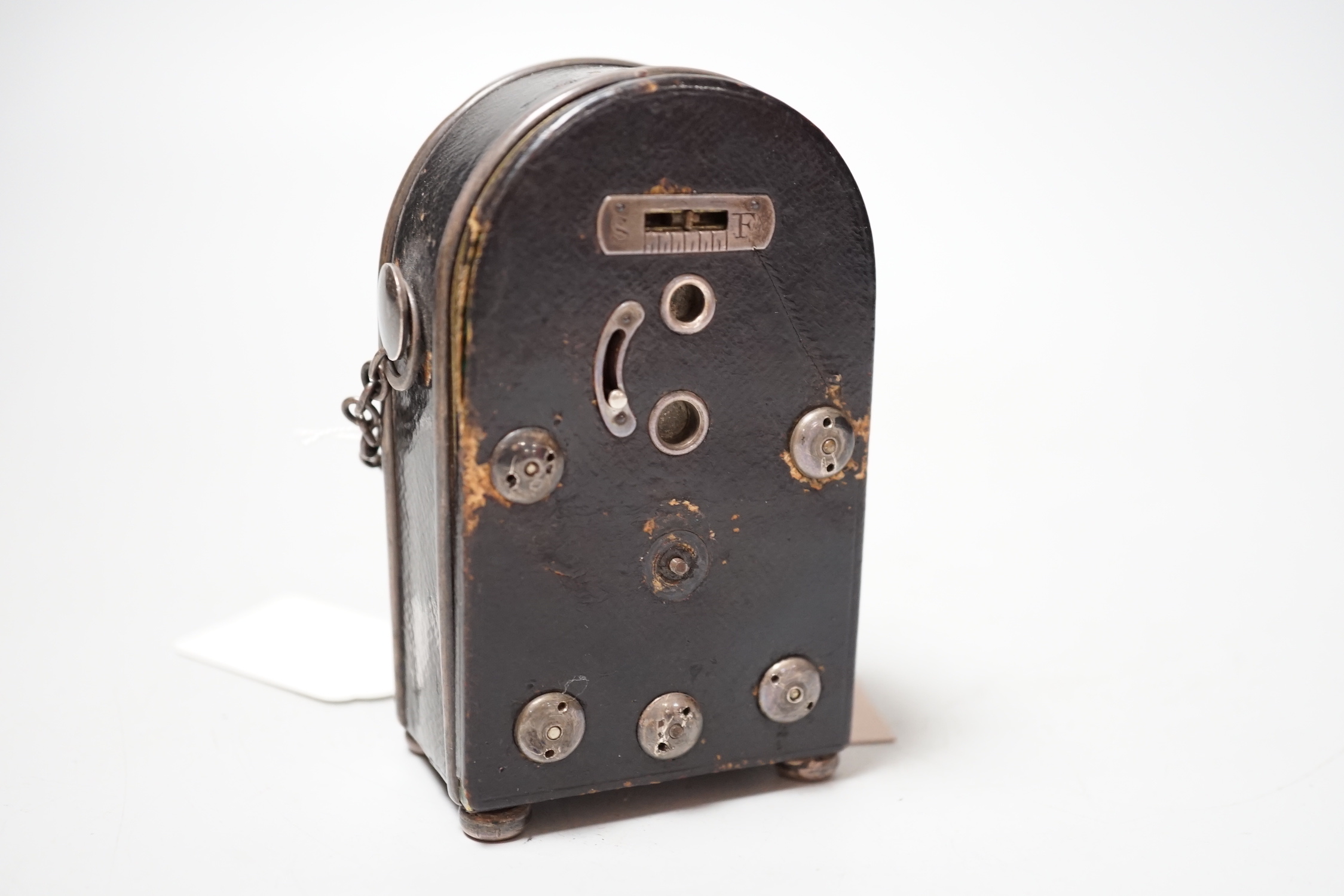 An unusual French White metal wall mounted black Morocco leather covered travelling timepiece, 9.5 cm high